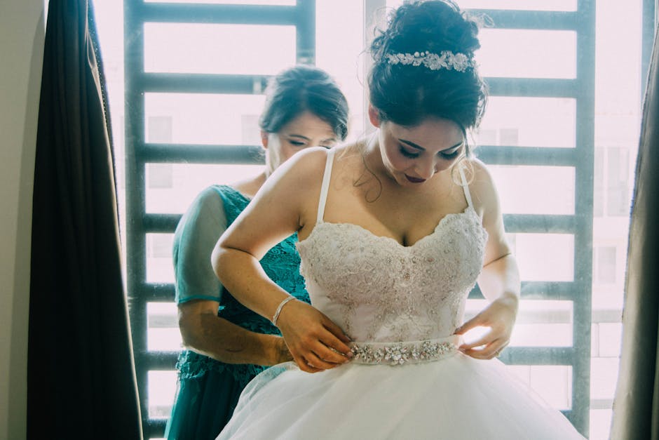 Wedding coordinator carefully adjusting a bride's wedding dress